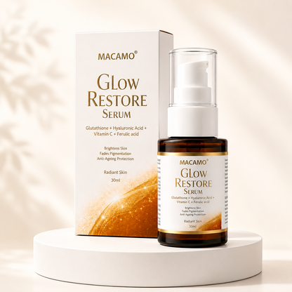MACAMO Glow Restore Serum shown with its white and gold retail box and a dark amber pump bottle on a white pedestal against a softly lit beige background.